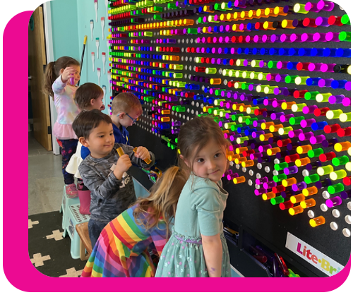 Children standing in front of a giant lite brite